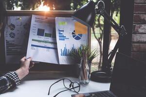 Project management updating financial chart with paperwork on board, work from home concept. photo