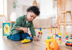 Concentrated latinos boy playing toys sitting on warm floor in modern living room. Baby development. Small tower. Learning creative concept photo