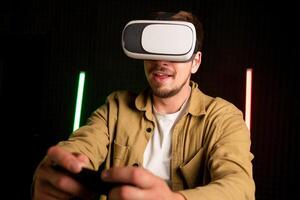 Virtual reality glass vr. Young man in digital glasses for 3d virtual reality game on dark background. Augmented reality, game, future technology concept. VR photo