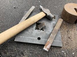 hole in a piece of thick steel, hand tools, hammer and chisel photo