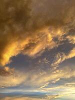 asombroso puesta de sol pintura el cielo con sombras de rojo y naranja, reflejado sutilmente en el agua para un Perfecto pacífico noche ambiente foto