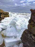 Crystalline ice sheets fracture and float on Russia's Lake Ladoga, capturing the stark beauty of spring's thaw under a clouded sky. photo