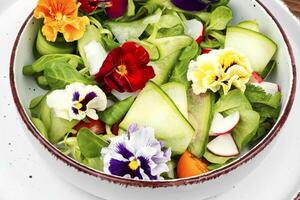 Colorful vegetable salad with edible flowers. photo