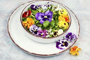 Salad of edible flowers, vegetarian food. photo