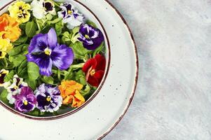 Pansy salad of edible flowers, healthy food. photo
