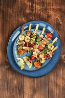 Seafood kebabs on wooden background. photo