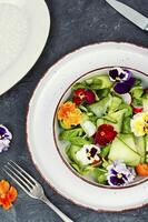 Fresh green salad of vegetables and flowers. photo