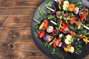 A la parrilla vegetales en brochetas, espacio para texto. foto