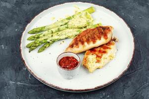 Chicken fillet cooked on a grill and garnish of asparagus. photo