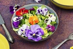 Salad of edible flowers, vegetarian food. photo