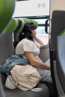 A girl rides a train sitting at the window. The girl looks sadly out of the window, saying goodbye to her relatives, she leaves for another city. photo