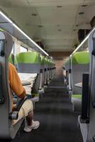 A half-empty passenger car of a high-speed train. A man enjoys a train ride. Traveling by train. Transport in Germany. photo