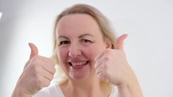 Banner Image of european american business woman smiling, pointing showing thumb up, recommending product, cool super praising, standing on white background advertising space for text closeup video