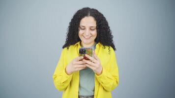 Happy young woman texting on the phone. Smiling. video