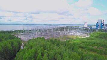 estate Visualizza a partire dal il elicottero. clip. verde foresta Il prossimo per il costruzione la zona e tubi e blu luminosa leggermente nebbioso luminosa nuvole. video