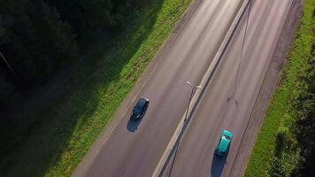 oben Aussicht von schwarz Auto Fahren entlang Wald Autobahn. Clip. Verfolgung Auto Fahren entlang Autobahn auf Hintergrund von Grün Wald. Reisen durch Auto entlang Wald Autobahn auf sonnig Sommer- Tag video