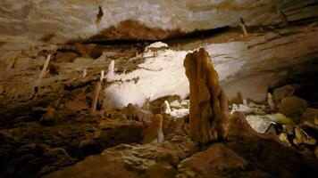 se inuti av underjordisk grotta, begrepp av äventyr och speleologi. handling. stenar och solsken inuti en grotta. video
