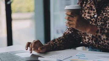 Close up Business woman using calculator and laptop for do math finance on wooden desk, tax, accounting, statistics and analytical research concept video