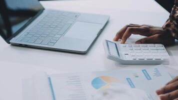 Close up Business woman using calculator and laptop for do math finance on wooden desk, tax, accounting, statistics and analytical research concept video