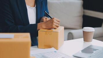 puesta en marcha pequeño negocio empresario de Lanza libre asiático mujer utilizando un ordenador portátil con caja alegre éxito en línea márketing embalaje caja y entrega SME idea concepto video