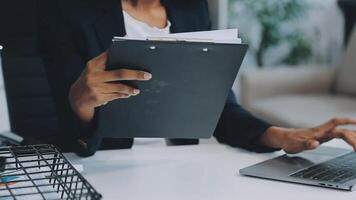 cierre a una mujer de negocios usando una calculadora y una computadora portátil para hacer finanzas matemáticas en un escritorio de madera, impuestos, contabilidad, estadísticas y concepto de investigación analítica video