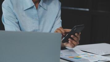 Asian woman holding smartphone, businesswoman using smartphone for social media and messaging with friends, using smartphone to send work email. Concepts of communication via the internet. video
