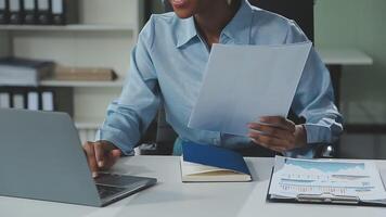 Close up Business woman using calculator and laptop for do math finance on wooden desk, tax, accounting, statistics and analytical research concept video