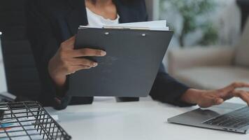 close-up mulher de negócios usando calculadora e laptop para fazer finanças matemáticas na mesa de madeira, impostos, contabilidade, estatística e conceito de pesquisa analítica video