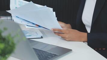 Close up Business woman using calculator and laptop for do math finance on wooden desk, tax, accounting, statistics and analytical research concept video