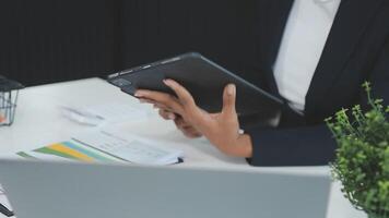 Close up Business woman using calculator and laptop for do math finance on wooden desk, tax, accounting, statistics and analytical research concept video