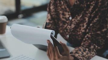 close-up mulher de negócios usando calculadora e laptop para fazer finanças matemáticas na mesa de madeira, impostos, contabilidade, estatística e conceito de pesquisa analítica video