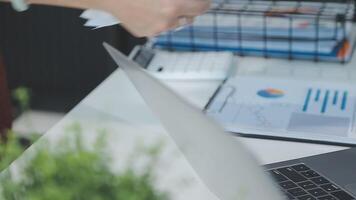 Close up Business woman using calculator and laptop for do math finance on wooden desk, tax, accounting, statistics and analytical research concept video