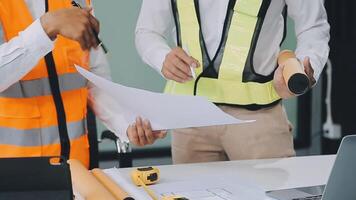 civil ingeniero equipos reunión trabajando juntos vestir trabajador cascos casco de seguridad en construcción sitio en moderno ciudad. capataz industria proyecto gerente ingeniero trabajo en equipo. asiático industria profesional equipo. video