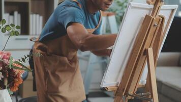 over- de schouder selectief focus schot van mannetje artiest gebruik makend van borstel terwijl toevoegen kleur verf naar potlood tekening Aan canvas video