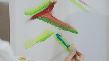 plus de le épaule sélectif concentrer coup de Masculin artiste en utilisant brosse tandis que ajouter Couleur peindre à crayon dessin sur Toile video