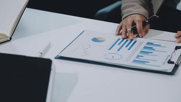 Businessmen meet to consult, brainstorm ideas, record on notepads. Brainstorming of colleagues in the office, project analysis report Check investment results and profits of the company. video
