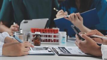 médico, encontro e computador portátil para equipe dentro escritório dentro discussão, debate e planejamento. doutor, enfermeira e computador em mesa, trabalho em equipe ou oficina para dados análise. video