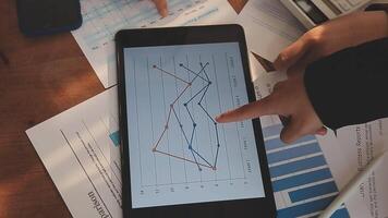 Financial analysts analyze business financial reports on a digital tablet planning investment project during a discussion at a meeting of corporate showing the results of their successful teamwork. video