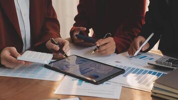 Financial analysts analyze business financial reports on a digital tablet planning investment project during a discussion at a meeting of corporate showing the results of their successful teamwork. video