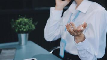 Asian businesswoman in formal suit in office happy and cheerful during using smartphone and working video