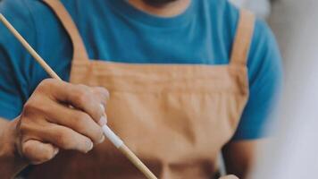 plus de le épaule sélectif concentrer coup de Masculin artiste en utilisant brosse tandis que ajouter Couleur peindre à crayon dessin sur Toile video