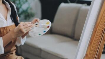 plus de le épaule sélectif concentrer coup de Masculin artiste en utilisant brosse tandis que ajouter Couleur peindre à crayon dessin sur Toile video