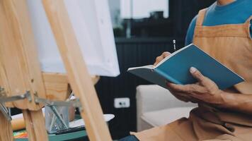 plus de le épaule sélectif concentrer coup de Masculin artiste en utilisant brosse tandis que ajouter Couleur peindre à crayon dessin sur Toile video