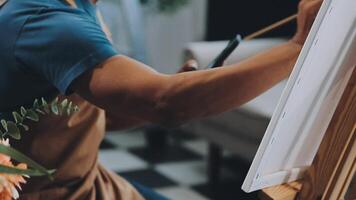 plus de le épaule sélectif concentrer coup de Masculin artiste en utilisant brosse tandis que ajouter Couleur peindre à crayon dessin sur Toile video