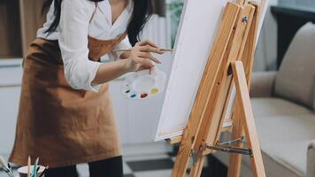 plus de le épaule sélectif concentrer coup de Masculin artiste en utilisant brosse tandis que ajouter Couleur peindre à crayon dessin sur Toile video