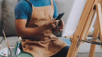 plus de le épaule sélectif concentrer coup de Masculin artiste en utilisant brosse tandis que ajouter Couleur peindre à crayon dessin sur Toile video