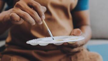 plus de le épaule sélectif concentrer coup de Masculin artiste en utilisant brosse tandis que ajouter Couleur peindre à crayon dessin sur Toile video