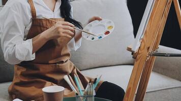 plus de le épaule sélectif concentrer coup de Masculin artiste en utilisant brosse tandis que ajouter Couleur peindre à crayon dessin sur Toile video