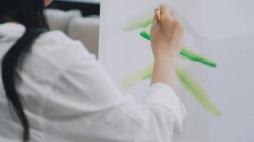 plus de le épaule sélectif concentrer coup de Masculin artiste en utilisant brosse tandis que ajouter Couleur peindre à crayon dessin sur Toile video