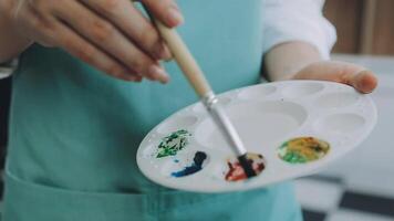 plus de le épaule sélectif concentrer coup de Masculin artiste en utilisant brosse tandis que ajouter Couleur peindre à crayon dessin sur Toile video